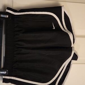 Nike women's size M black shorts, white trim, loose fitting with elastic waist.